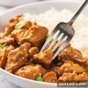 A fork stabbing a piece of crockpot orange chicken