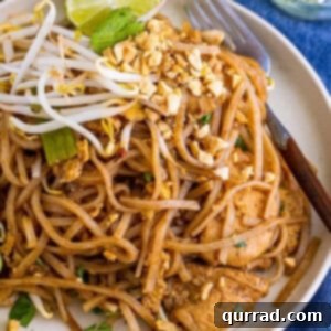 Close-up of a plate of Chicken Pad Thai with fresh garnishes.