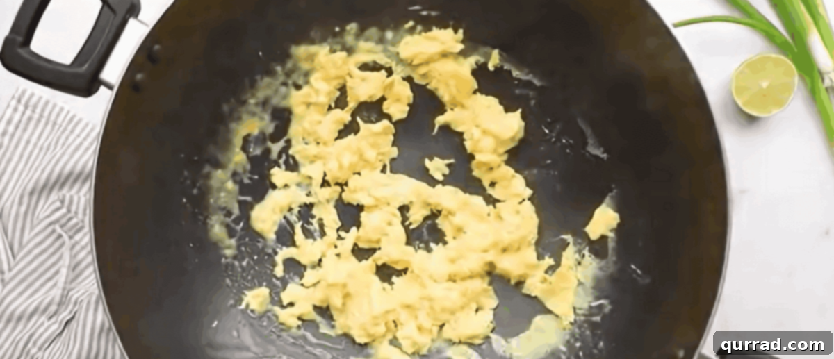 Chicken Pad Thai Perfection 6 Well-beaten eggs being poured into a hot wok and gently scrambled until just set.
