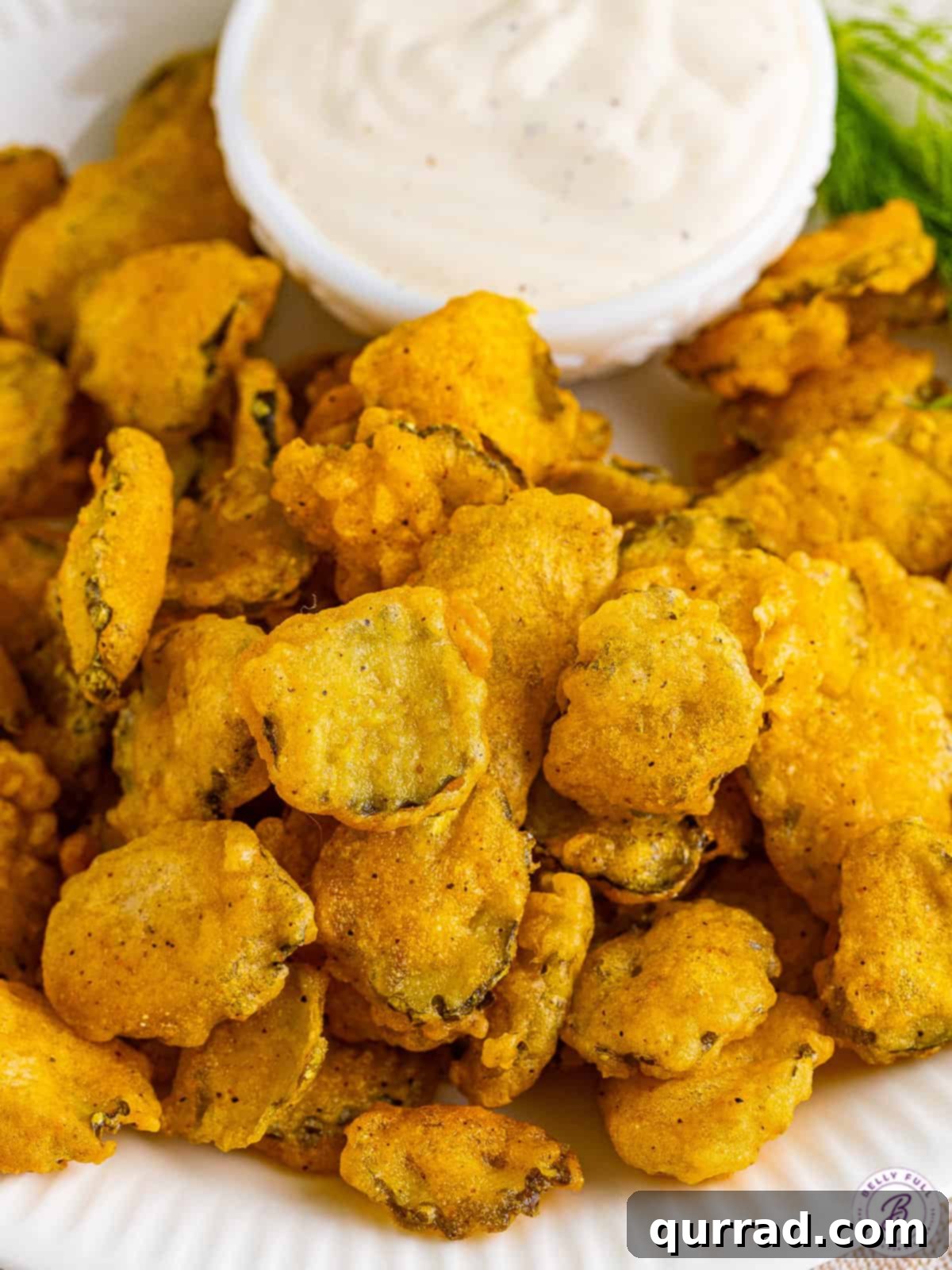 Crispy Homemade Fried Pickles with Ranch Dip Overhead view of perfectly golden-brown fried pickles arranged artfully around a small bowl of creamy ranch dipping sauce.