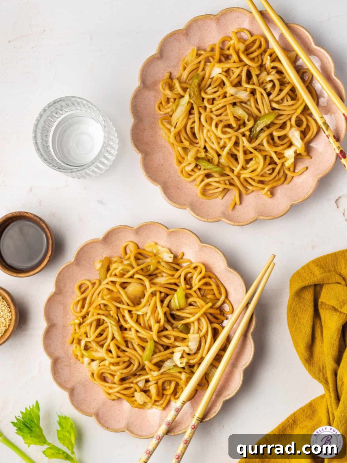 This copycat Panda Express Chow Mein recipe comes together in as little as 20 minutes! Enjoy with your other carryout favorites. Overhead view of two plates of panda express chow mein, garnished and ready to serve.