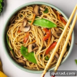 Overhead view of a bowl of veggie lo mein with chopsticks