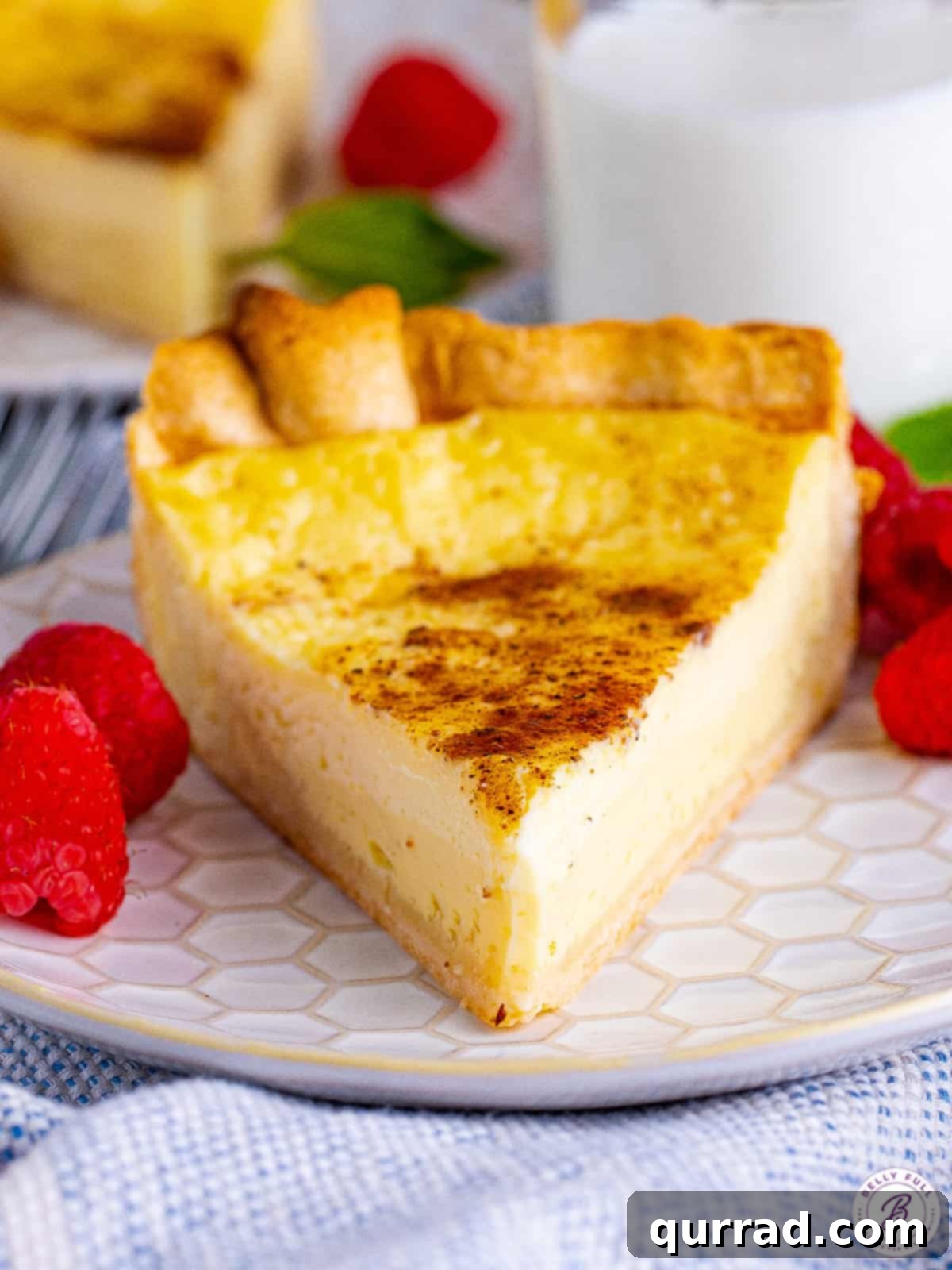 This Easy Custard Pie is a classic, simple dessert made with just 8 ingredients, offering a rich and creamy filling that isn't too sweet. A full creamy custard pie sitting on a white background, highlighting its golden crust and smooth surface.