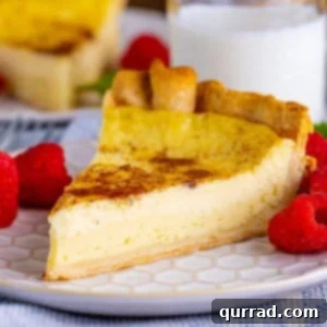 A slice of custard pie with berries on a white plate