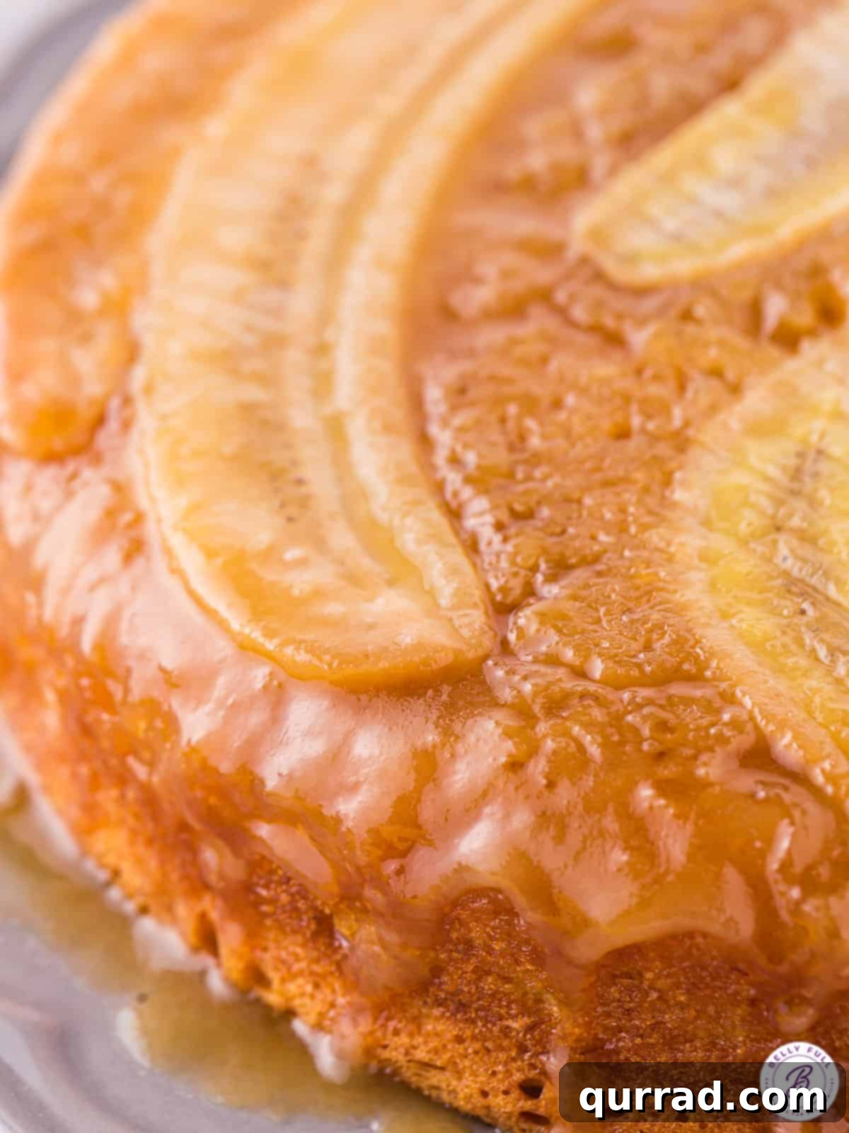 Golden Caramel Banana Flip 3 Close-up shot of the glistening caramelized banana topping on a freshly baked Banana Upside Down Cake, highlighting the rich brown sugar and butter sauce and perfectly arranged banana slices.