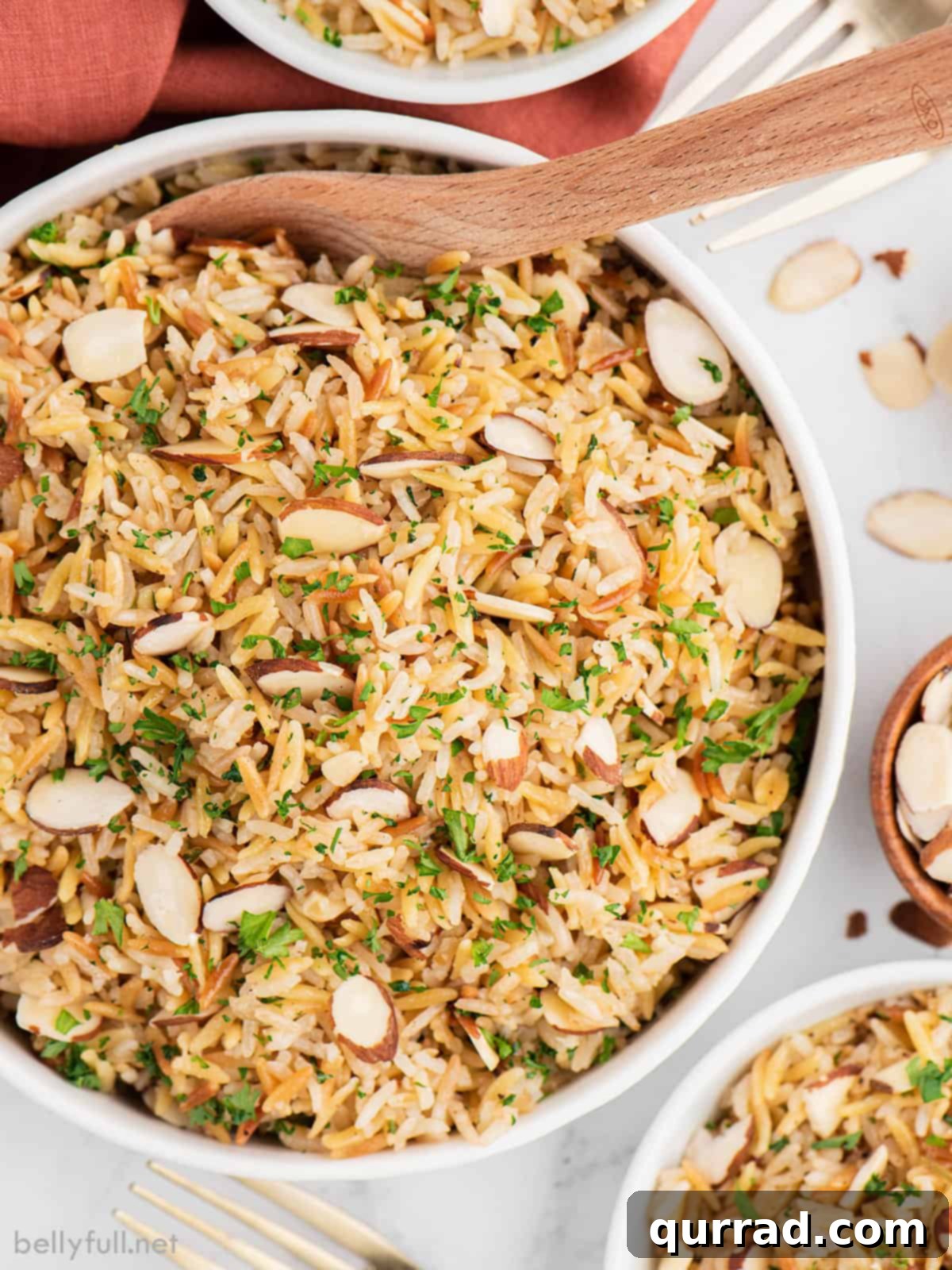 This Instant Pot Rice Pilaf comes out perfectly each time, with a rich, nutty flavor and lovely crunch from the sliced almonds. A wooden spoon in a bowl of rice pilaf
