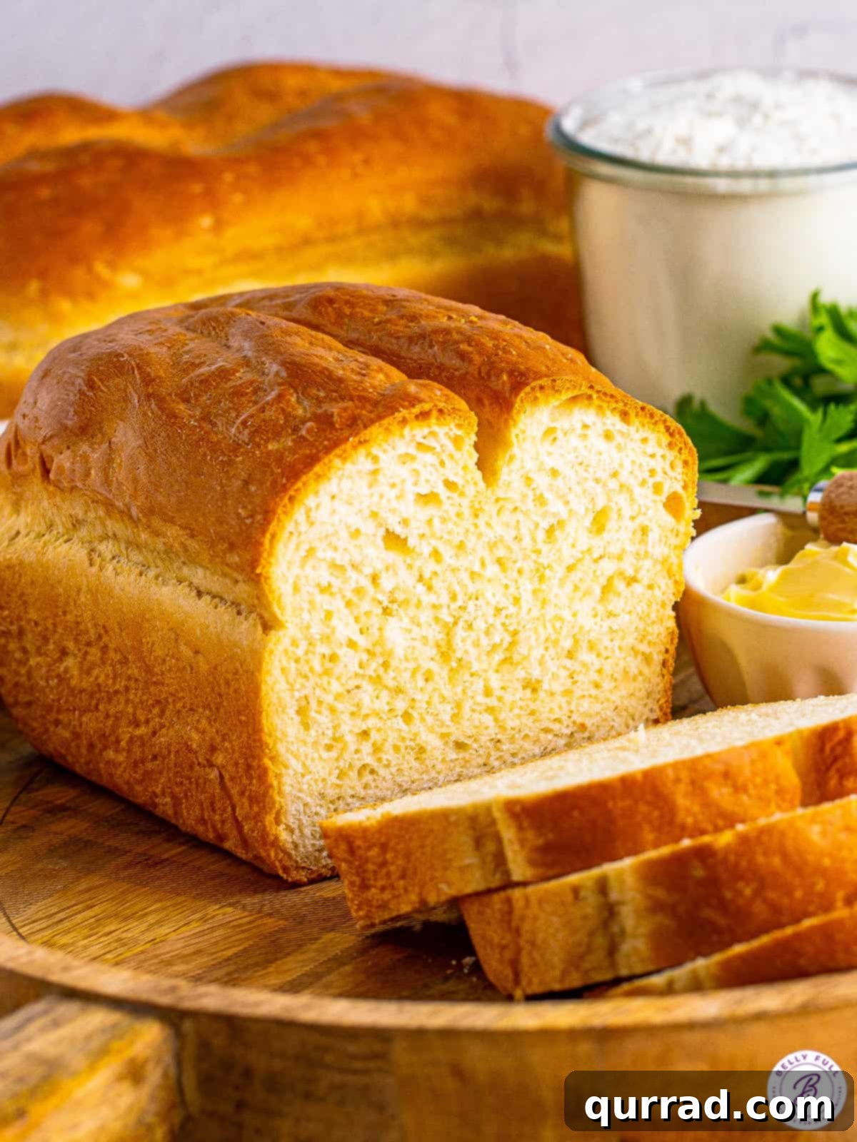 A loaf of homemade white bread, with a few pieces sliced