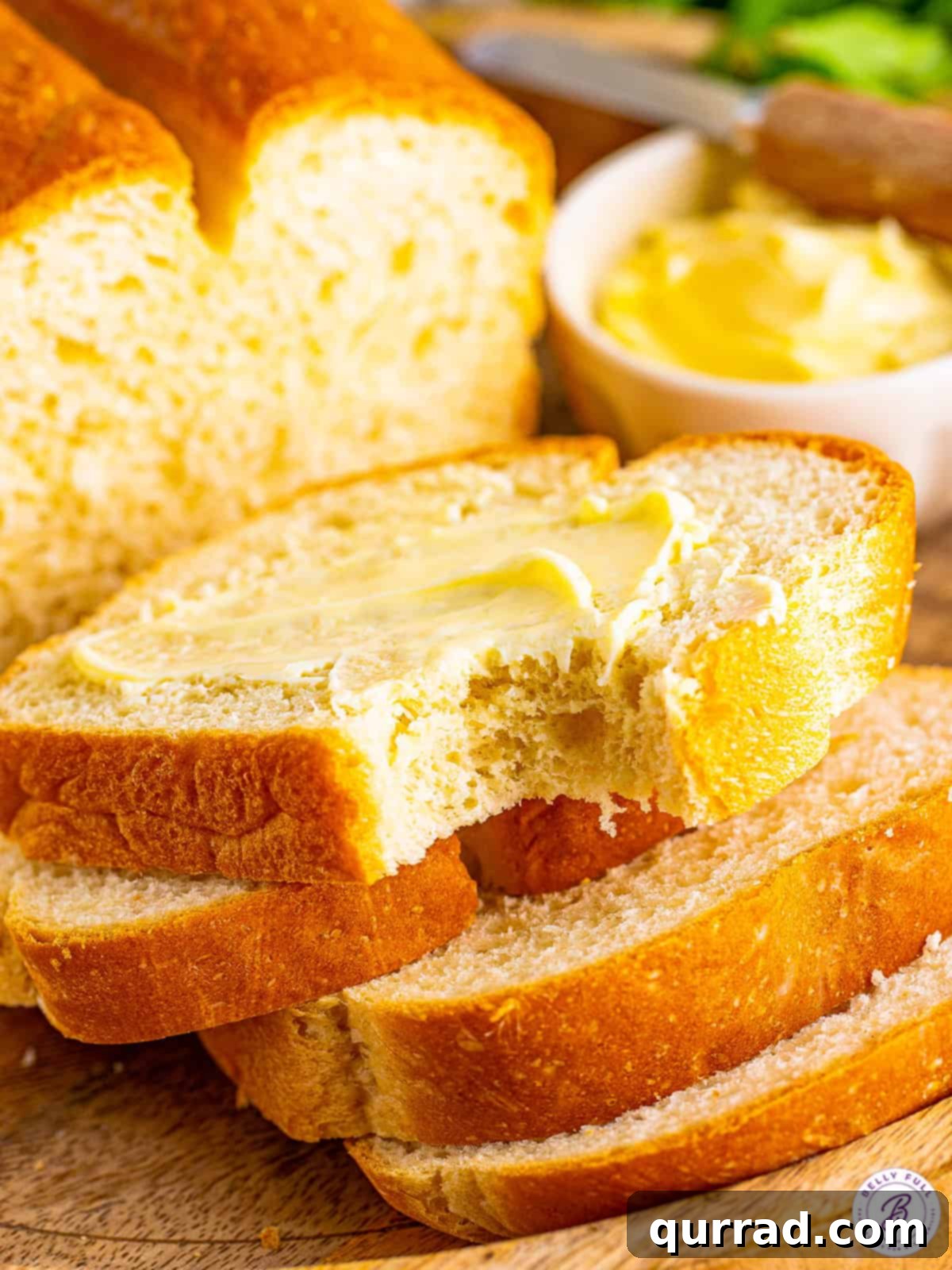 A slice of white bread slathered with butter