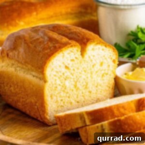 A loaf of homemade white bread, with a few pieces sliced