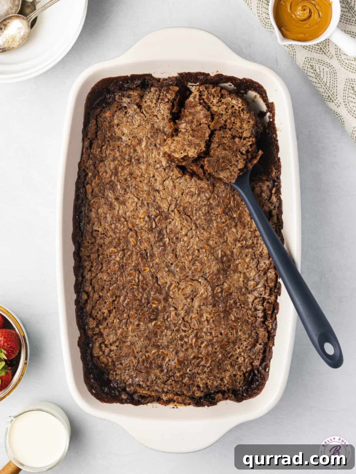 An overhead view of a baking dish filled with freshly baked brownie oatmeal, ready to be served, highlighting its rich, dark color and cracked top.
