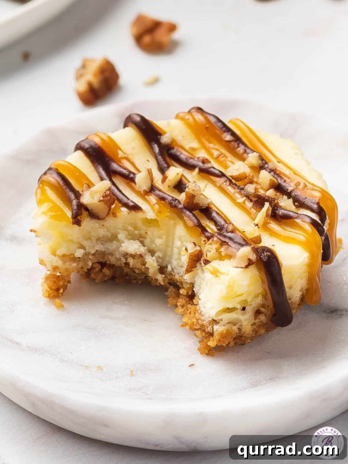 Topped with caramel, chocolate, and pecans these Mini Turtle Cheesecakes are a spin off the traditional candy. Easy to make & no water bath! A mini turtles cheesecake with a bite missing