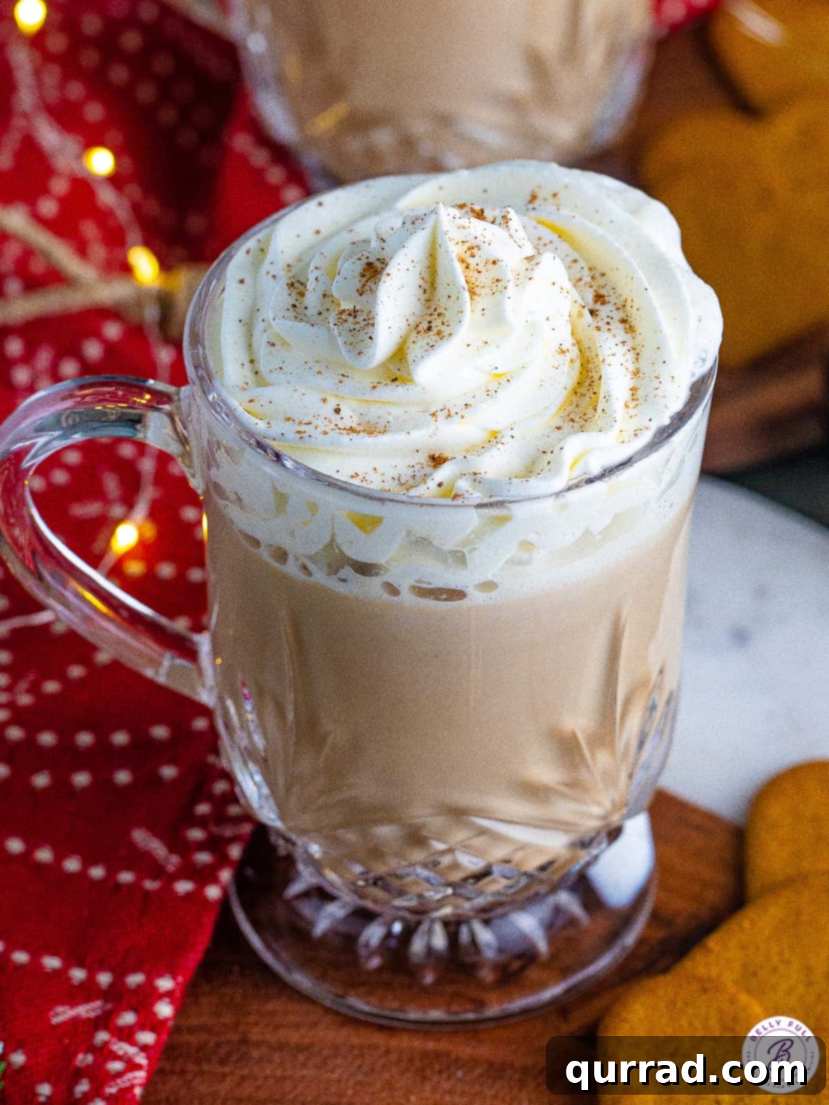 Espresso is sweetened with homemade gingerbread syrup and topped with frothed milk and whipped cream in this Gingerbread Latte recipe. Angled overhead view of a gingerbread latte, showcasing the whipped cream and spice topping