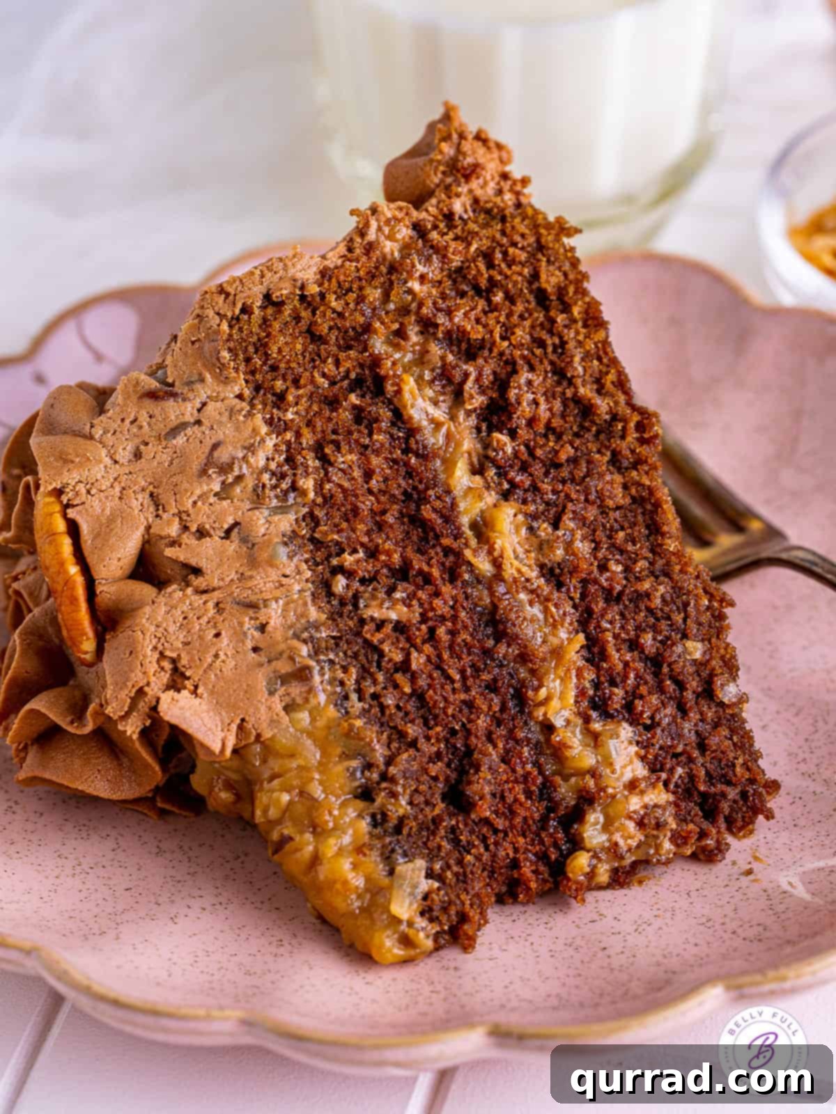 A slice of German Chocolate Cake showcasing its moist cake and abundant coconut pecan frosting. A perfectly cut slice of German chocolate cake, displaying its distinct layers on a pink plate.