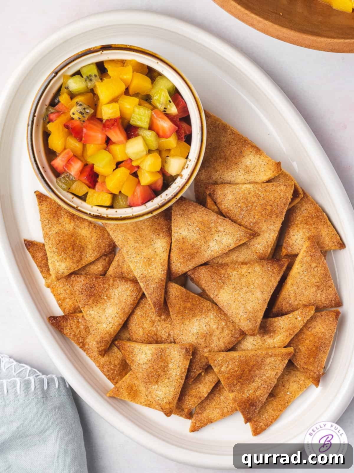 Fruit Salsa and Pie Crust Chips 2 Overhead shot of vibrant fruit salsa served with crispy cinnamon pie crust chips on a white platter, perfect for a summer dessert or snack.