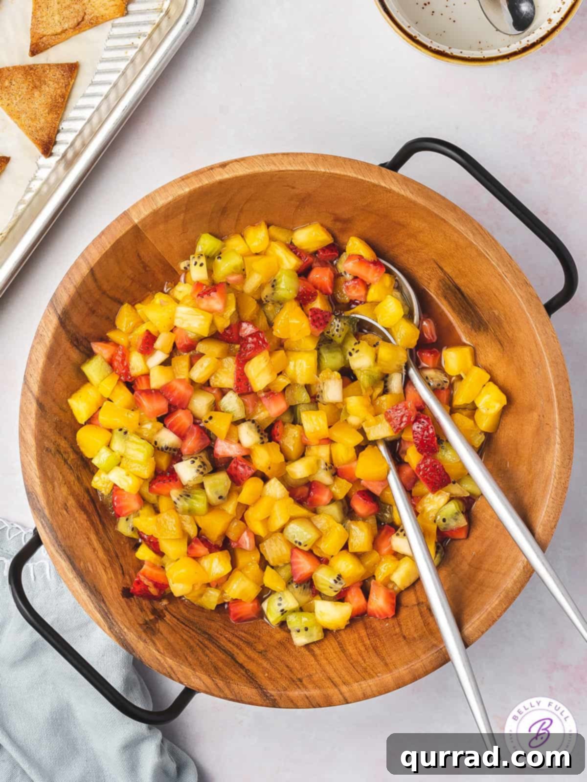 Fruit Salsa and Pie Crust Chips 3 Overhead view of a bowl of colorful fresh fruit salsa with serving spoons, ready to be enjoyed.
