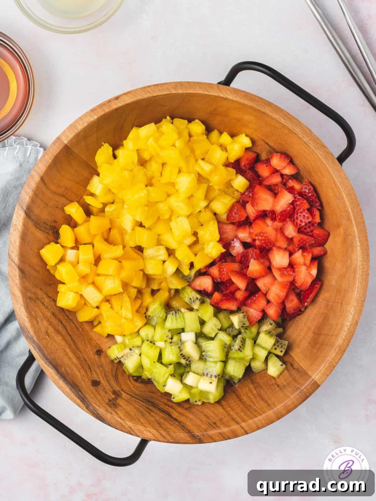 Fruit Salsa and Pie Crust Chips 4 Close-up overhead shot of various finely diced summer fruits in a wooden bowl, ready for making salsa.
