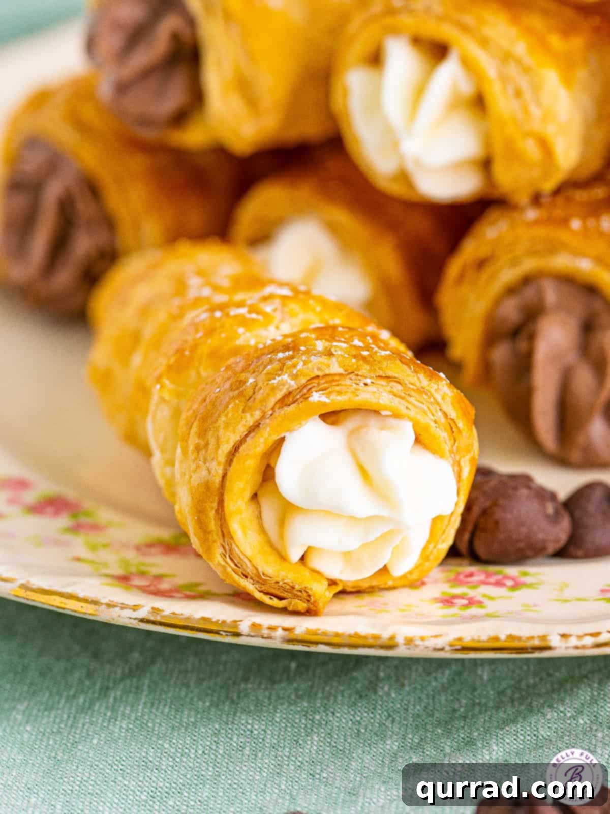 Close up of a vanilla cream horn puff pastry, highlighting its flaky layers and creamy filling.