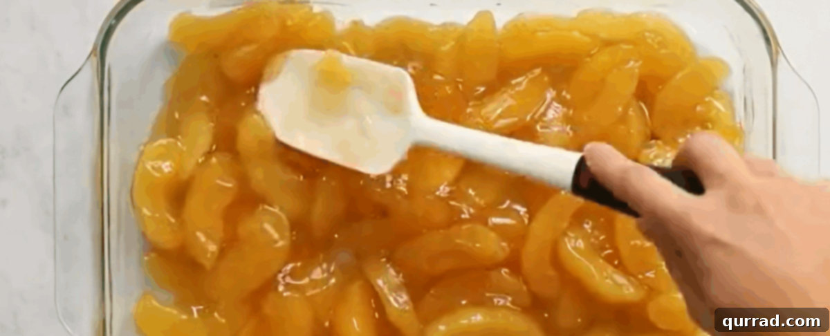 Irresistible Caramel Apple Dump Cake 4 Two cans of sweet apple pie filling spread evenly in the bottom of a glass 9x13 inch baking dish, ready for the next layer.