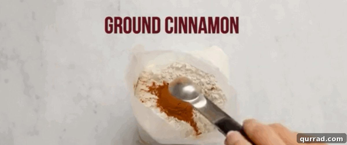 Irresistible Caramel Apple Dump Cake 5 A hand mixing ground cinnamon into a bag of dry yellow cake mix, illustrating how to infuse the topping with spice.