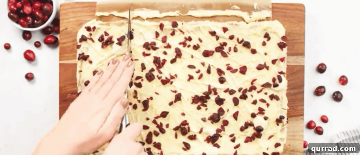 Cutting freshly frosted cranberry bliss bars into triangles.
