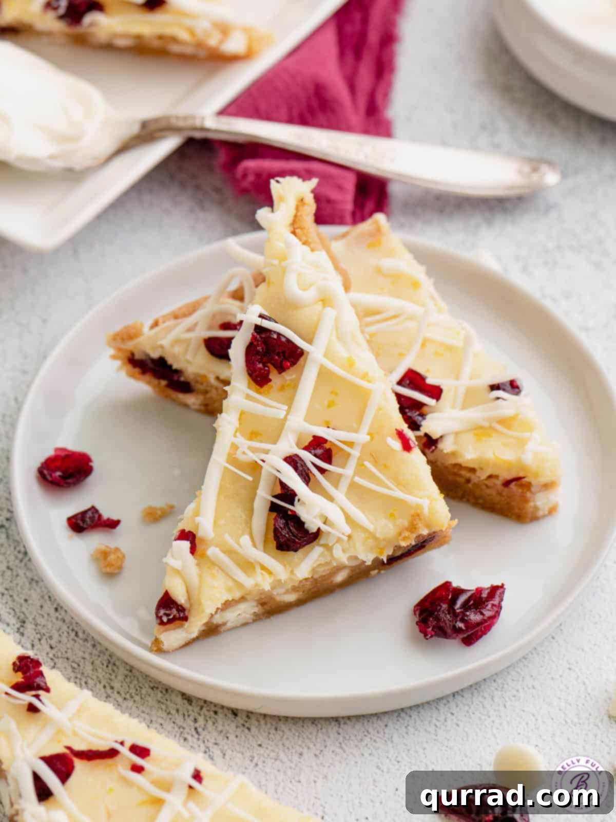 Two triangles of Starbucks cranberry bliss bars on a white plate, ready to be enjoyed.