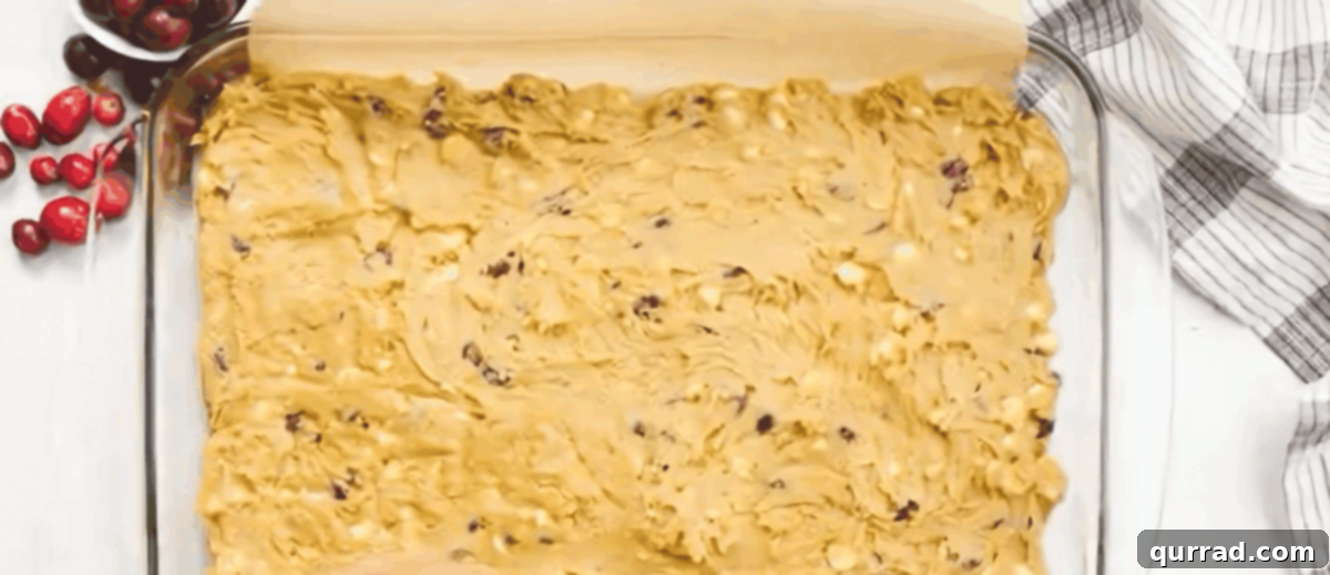 Cranberry bliss bar batter spread evenly in a glass baking dish.