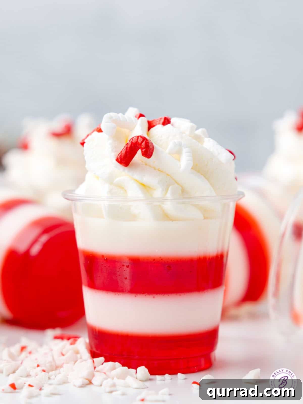 Peppermint Twist Shooters 2 A beautifully layered Candy Cane Jello Shot topped with a swirl of whipped cream and festive sprinkles, perfect for holiday parties.