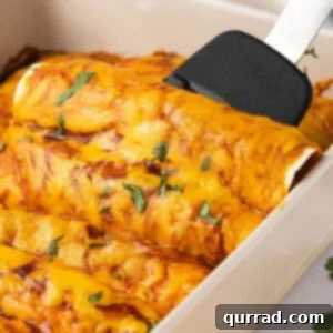 A spatula scooping out a perfectly baked beef and rice enchilada from a casserole dish, ready to serve.