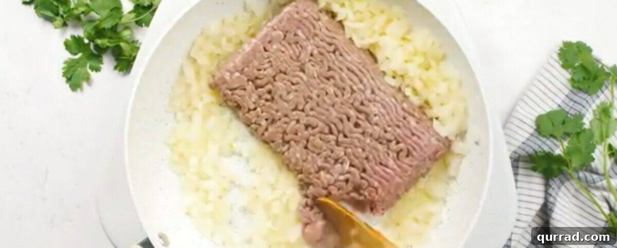 Cooking the ground beef with diced onions in a large nonstick skillet until the beef is browned and the onions are tender.