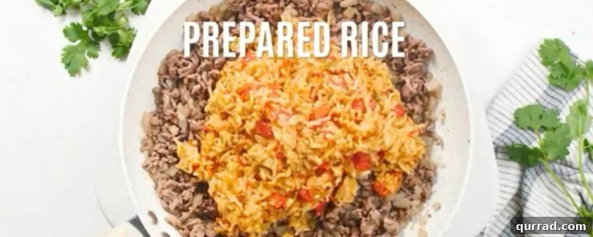 Combining the cooked ground beef mixture and Spanish rice with enchilada sauce in a skillet, stirring to incorporate.
