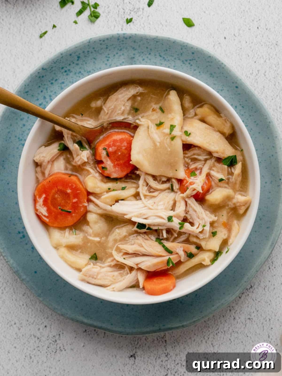 Homemade Chicken and Dumplings is a classic comfort food dish. This easy version is made with tender egg noodles & rotisserie chicken. Overhead view of a bowl of homemade chicken and dumplings.