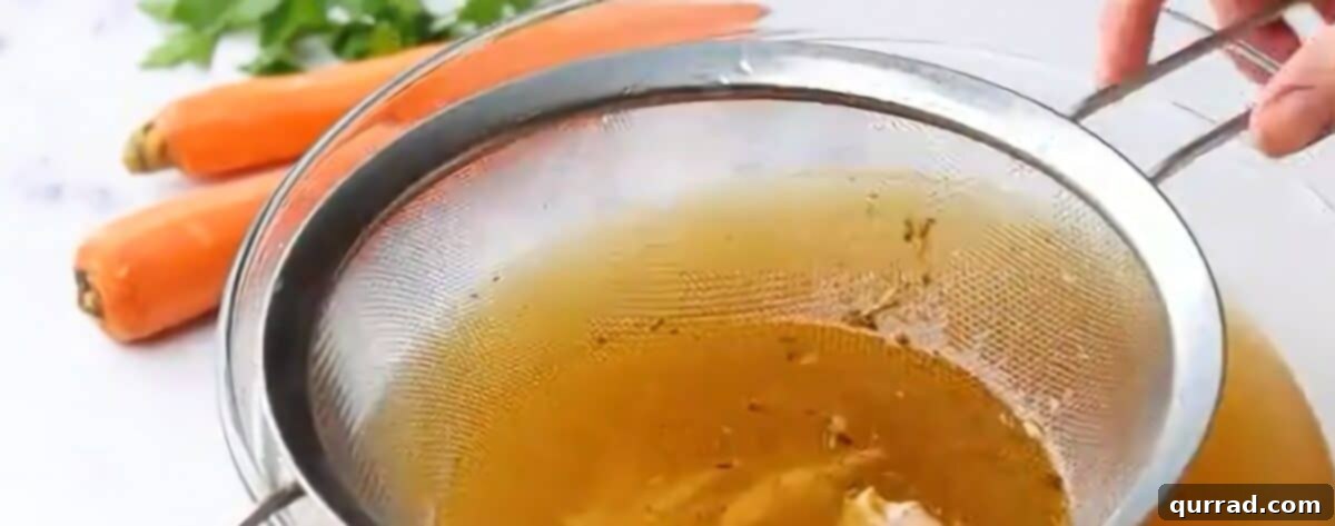 Southern Comfort Bowl 7 Straining the chicken broth through a mesh strainer.