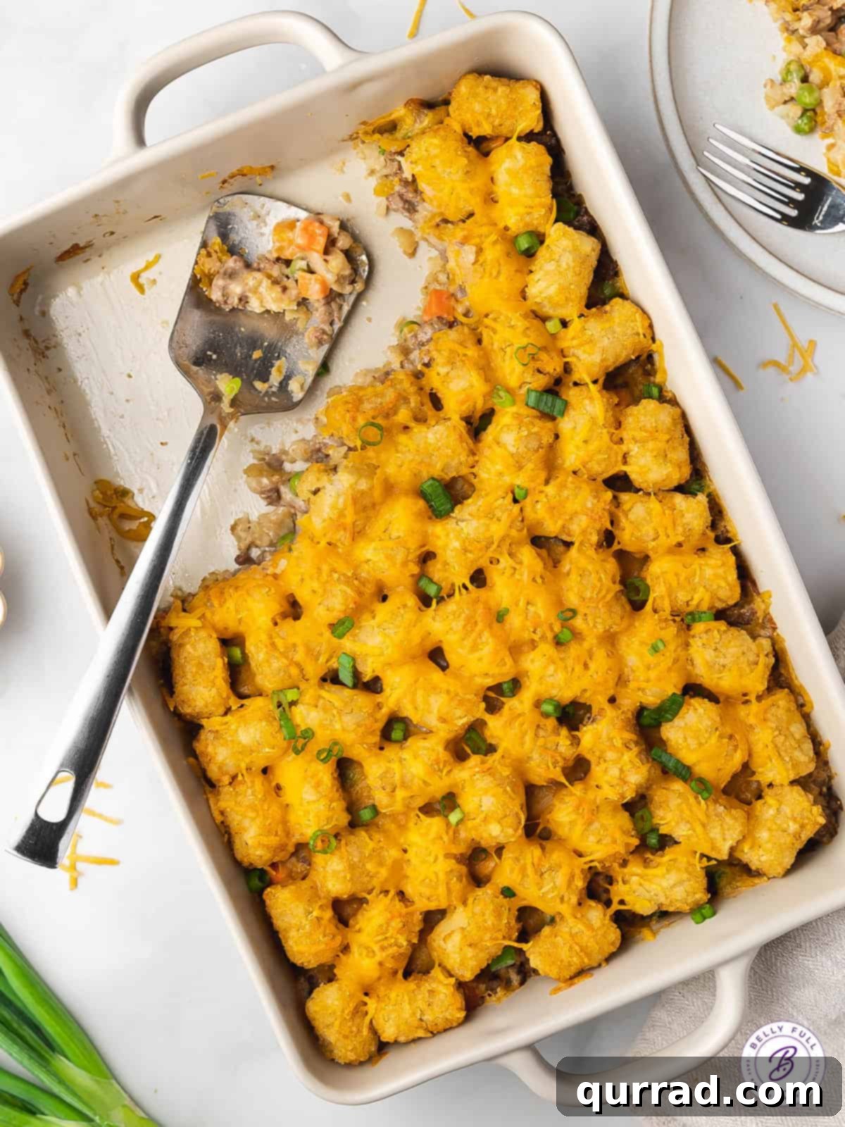Made with ground beef, tater tots, cheese, frozen veggies, and soup, this Cheeseburger Tater Tot Casserole makes a quick and easy dinner. Overhead view of a cheeseburger tater tot casserole, with a portion missing, inviting you to dig in.