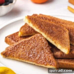 Diagonal halves of cinnamon sugar toast on a white plate