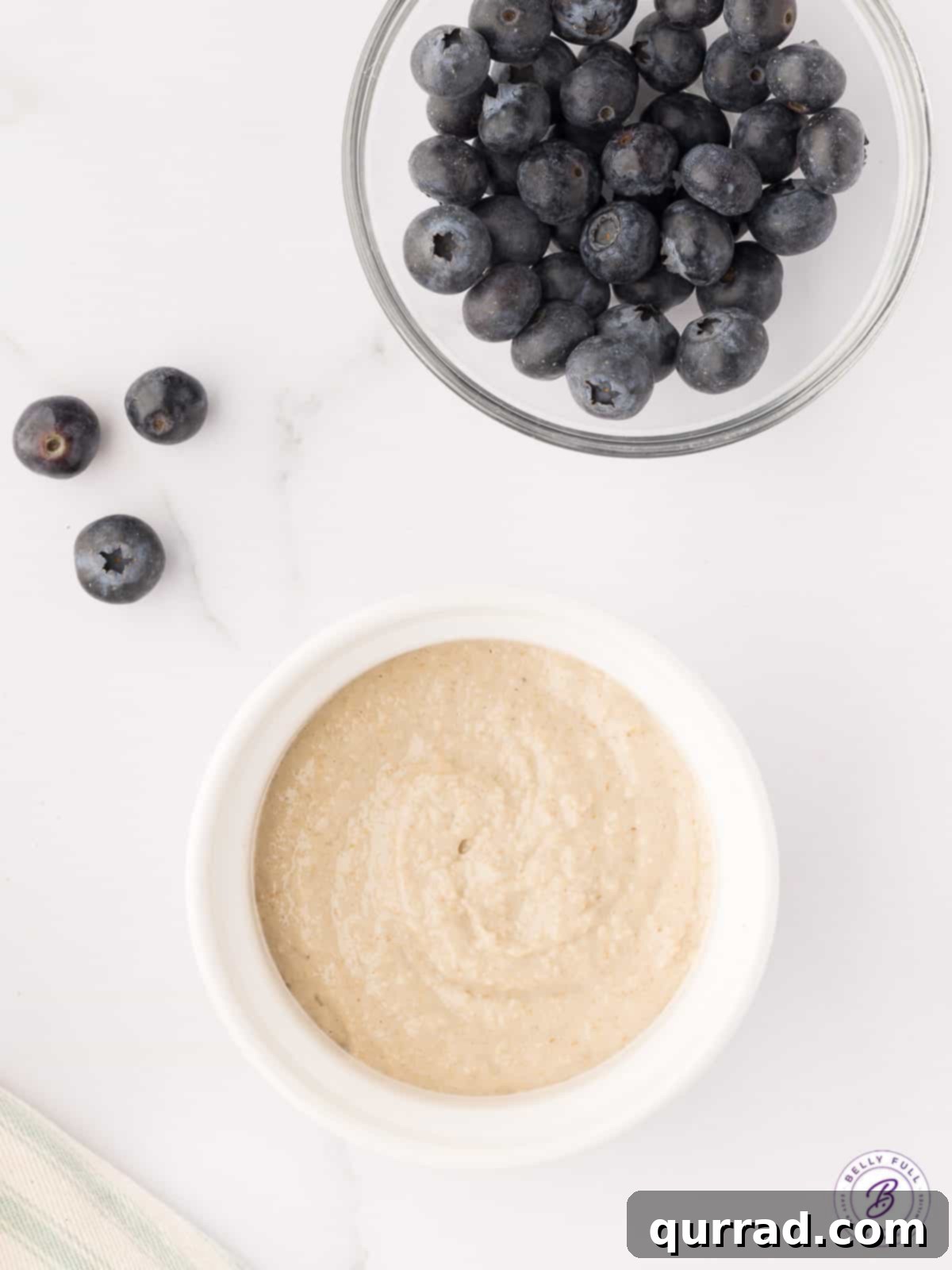 Blended Baked Oats: Simple ingredients for a wholesome and tasty breakfast. A ramekin filled with blended oat mixture next to a bowl of fresh blueberries, ready for baking.