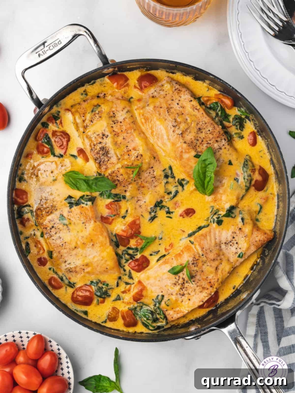 This Tuscan Butter Salmon recipe is super easy to make, but tastes like something you'd order at a 5-star restaurant! Ready in 30 minutes! Overhead view of Tuscan butter salmon in a skillet ready to be served