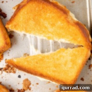Oven grilled cheese sandwich halves on a cutting board, ready to serve