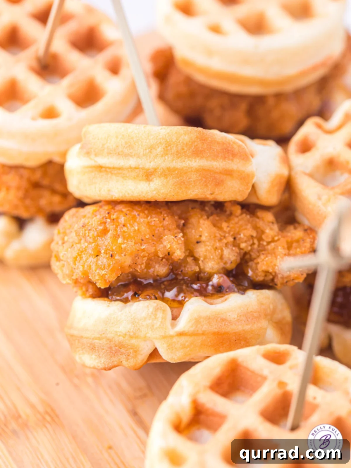 Delicious Chicken and Waffle Sliders: The ultimate sweet & savory game day bite. Close up of a chicken and waffle slider showing crispy chicken and fluffy waffle layers.
