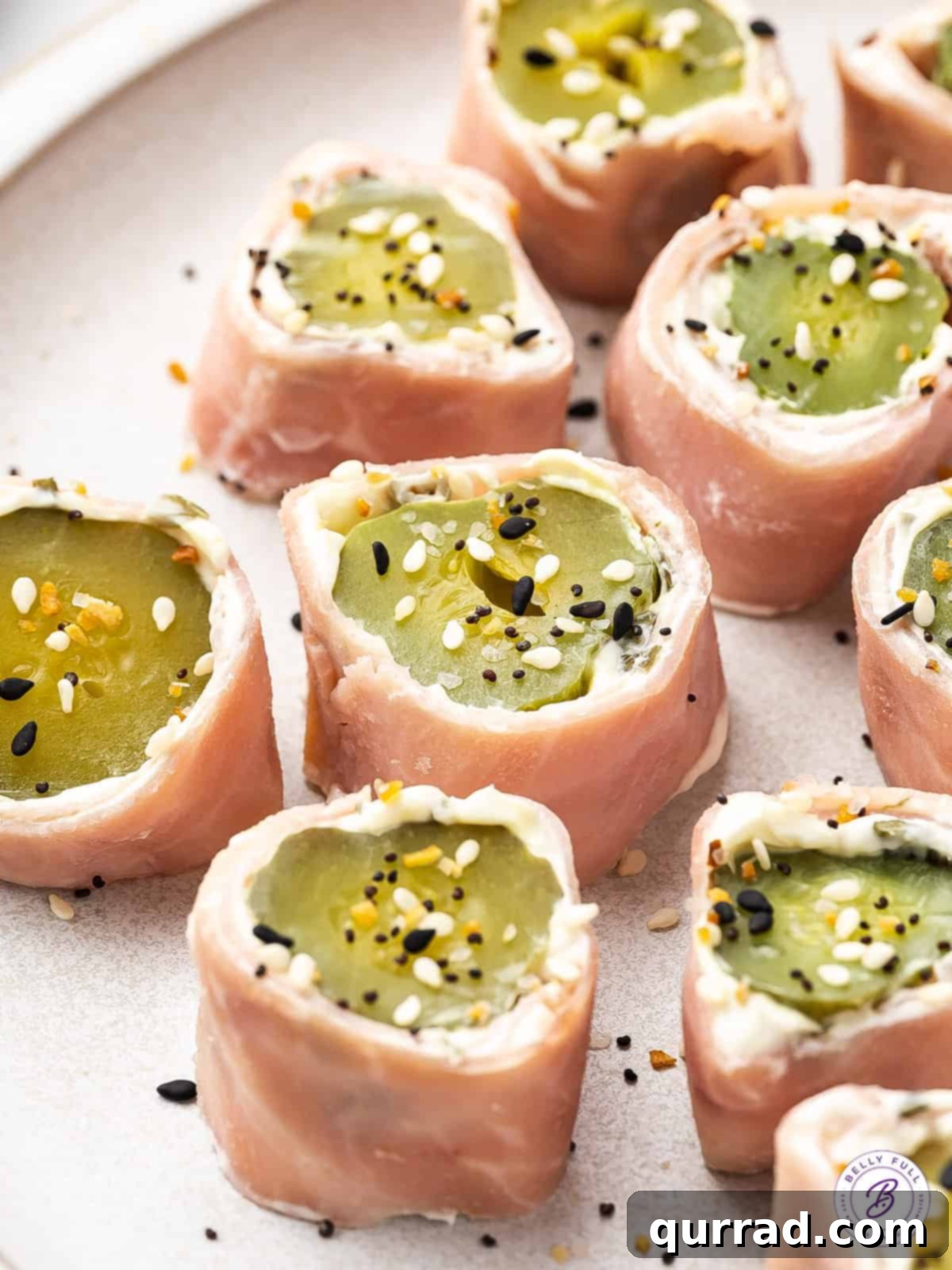 Ham Pickle Roll Ups are an easy and super delicious 3-ingredient snack or appetizer. Also referred to as Redneck Sushi, they're low carb! Overhead view of ham and pickle roll ups on a plate, garnished with everything bagel seasoning, highlighting their delicious appeal.