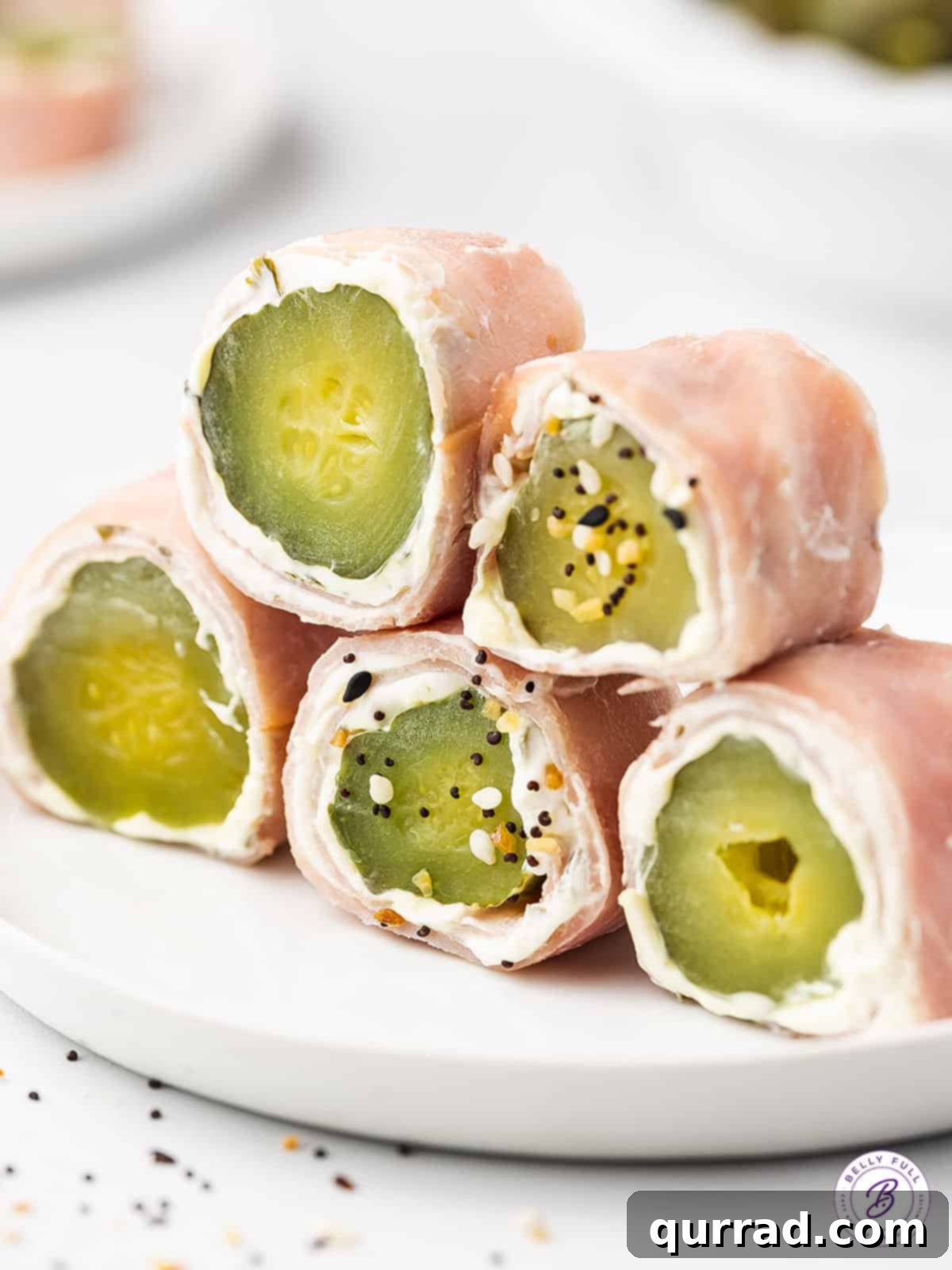 Ham Pickle Roll Ups are an easy and super delicious 3-ingredient snack or appetizer. Also referred to as Redneck Sushi, they're low carb! Ham pickle roll ups neatly stacked on a plate, showcasing their inviting presentation and perfect for a party.