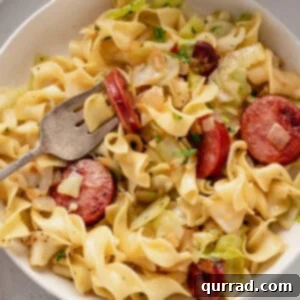 Hearty Haluski: Cabbage and Noodle Perfection 2 A fork in a bowl of fried cabbage and noodles