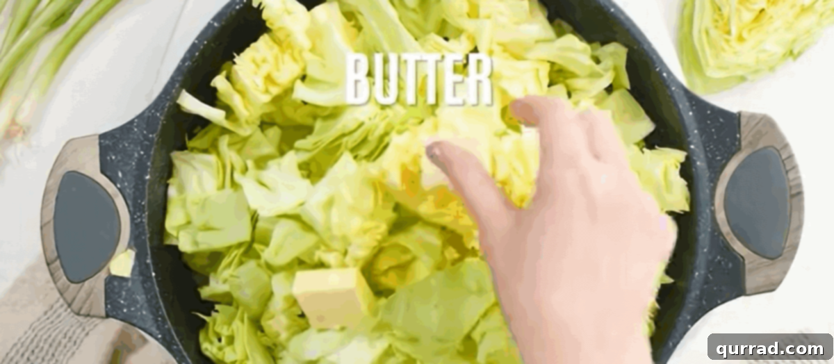 Hearty Haluski: Cabbage and Noodle Perfection 5 Sauteeing chopped cabbage, onions, and garlic in butter within a black skillet.