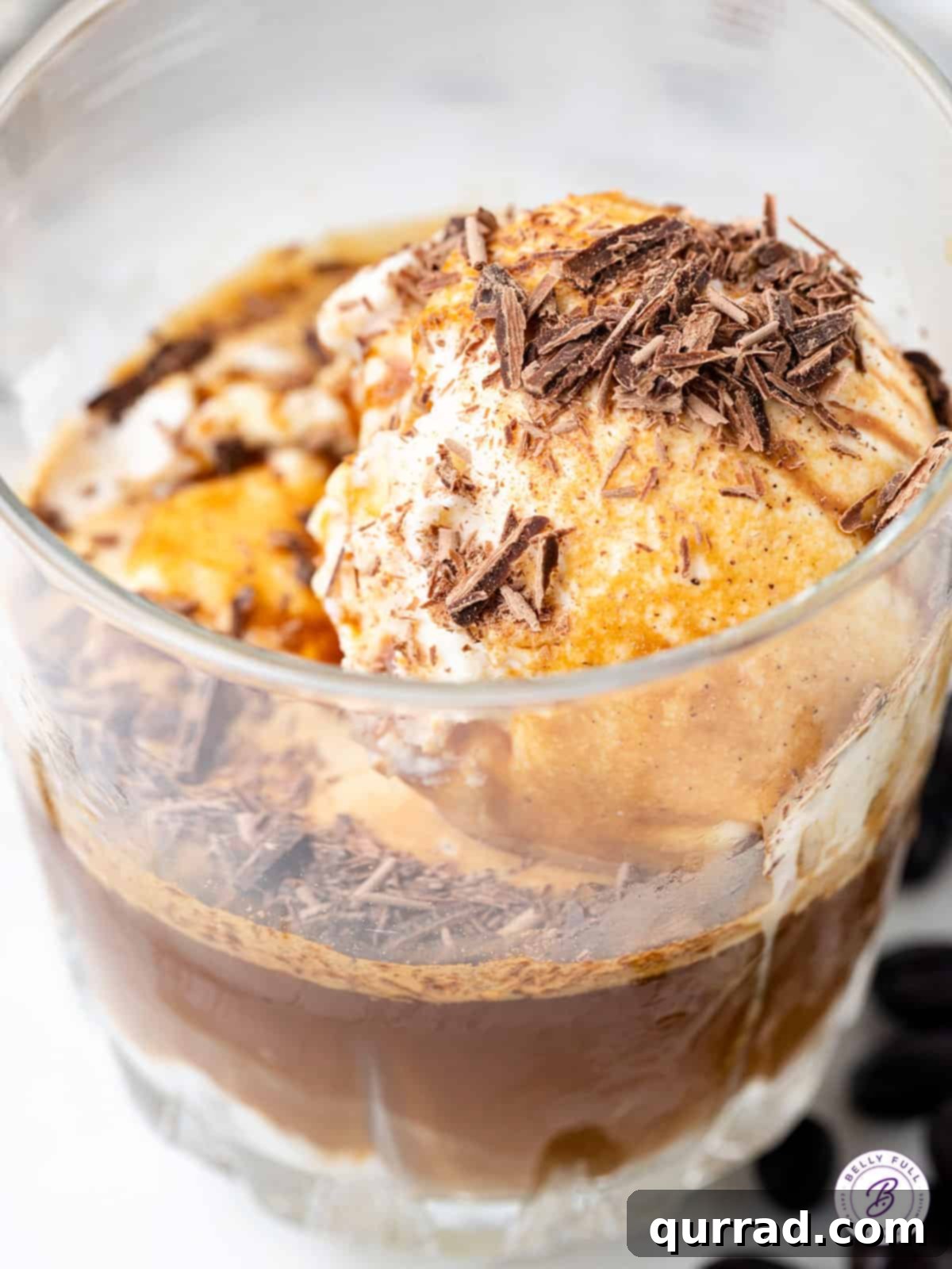 Make the perfect Affogato at home with just two ingredients - espresso and ice cream. Top with chocolate shavings for the perfect dessert. Close-up of a finished Affogato coffee, showing the melted ice cream and coffee layers.