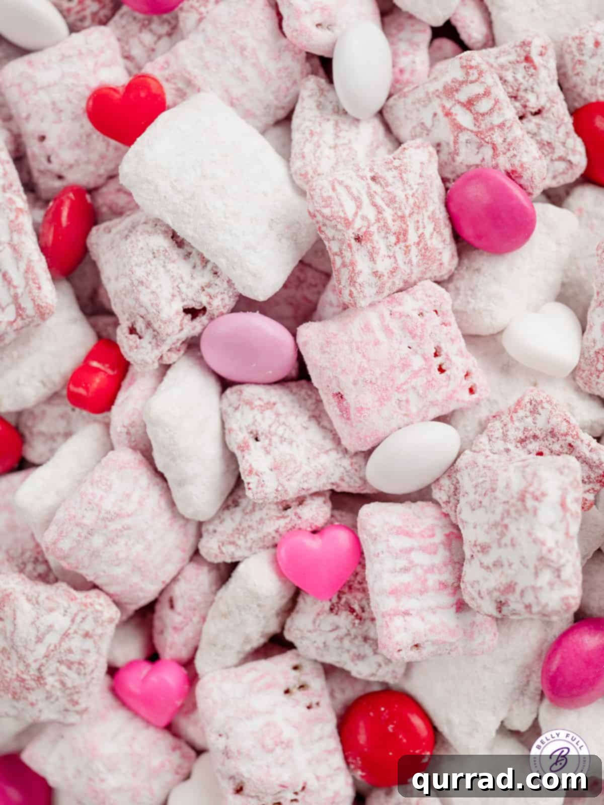 Close-up view of delicate pink and white muddy buddies adorned with small candy hearts, showcasing their festive appeal.