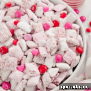 Valentine's Muddy Buddies with red, pink, and white M&Ms in a bowl, a festive treat.