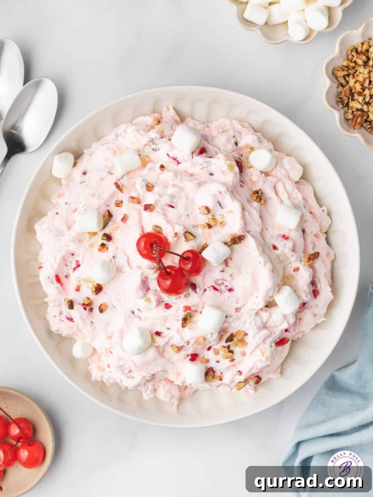 This Cherry Fluff is made with cream cheese, homemade whipped cream, maraschino cherries, and crushed pineapple for a quick and easy dessert. Overhead view of cherry fluff in a white bowl