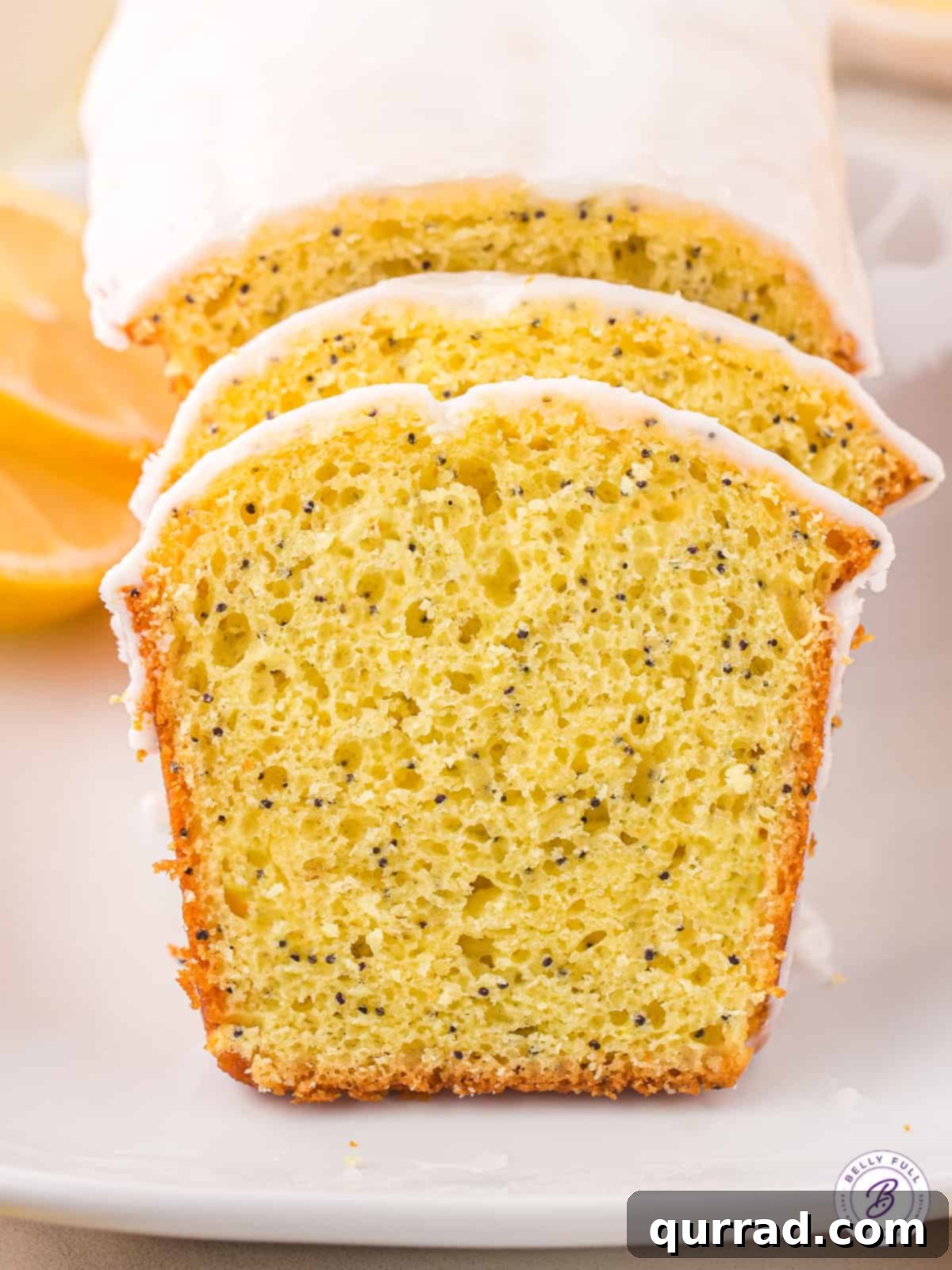 Two slices of lemon loaf with icing and poppy seeds