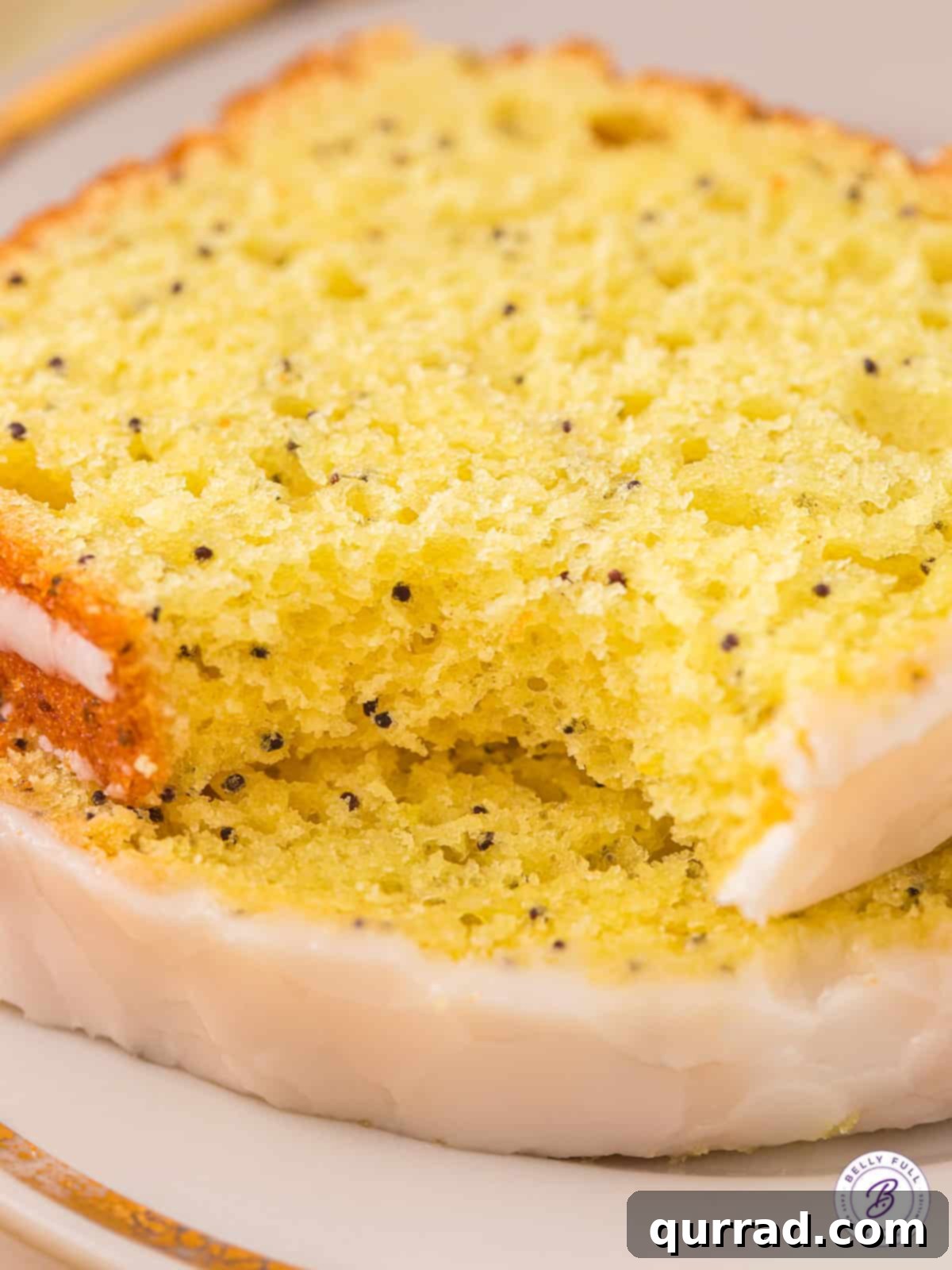 Two slices of lemon loaf with a bite missing, showcasing its soft texture