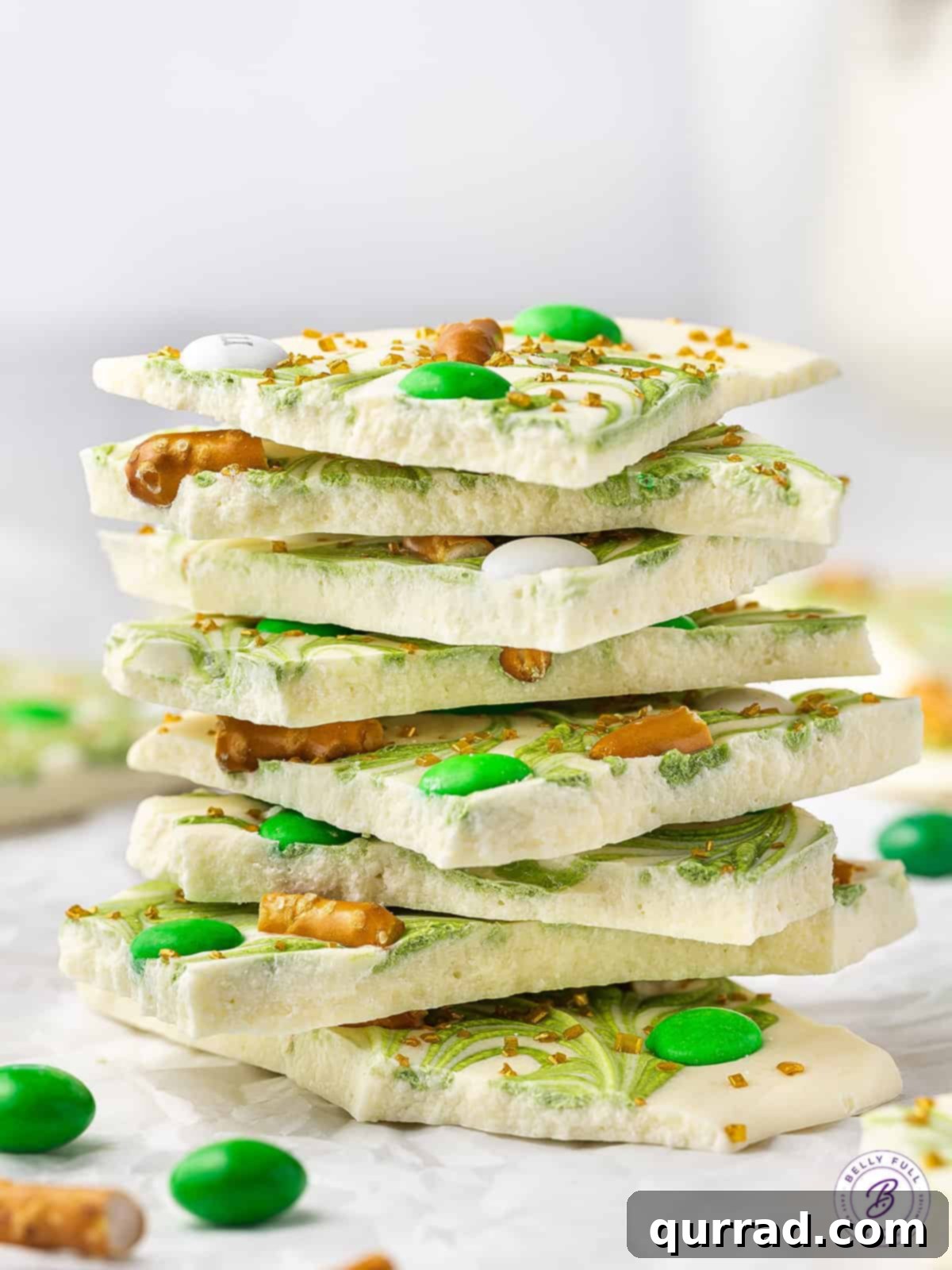 Stack of St. Patrick's Day white chocolate bark with pretzels and green M&Ms, ready to be served
