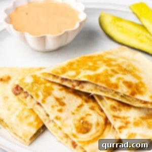 Savory Reuben Quesadillas 2 Slices of a corned beef quesadilla next to a little dish of thousand island dressing